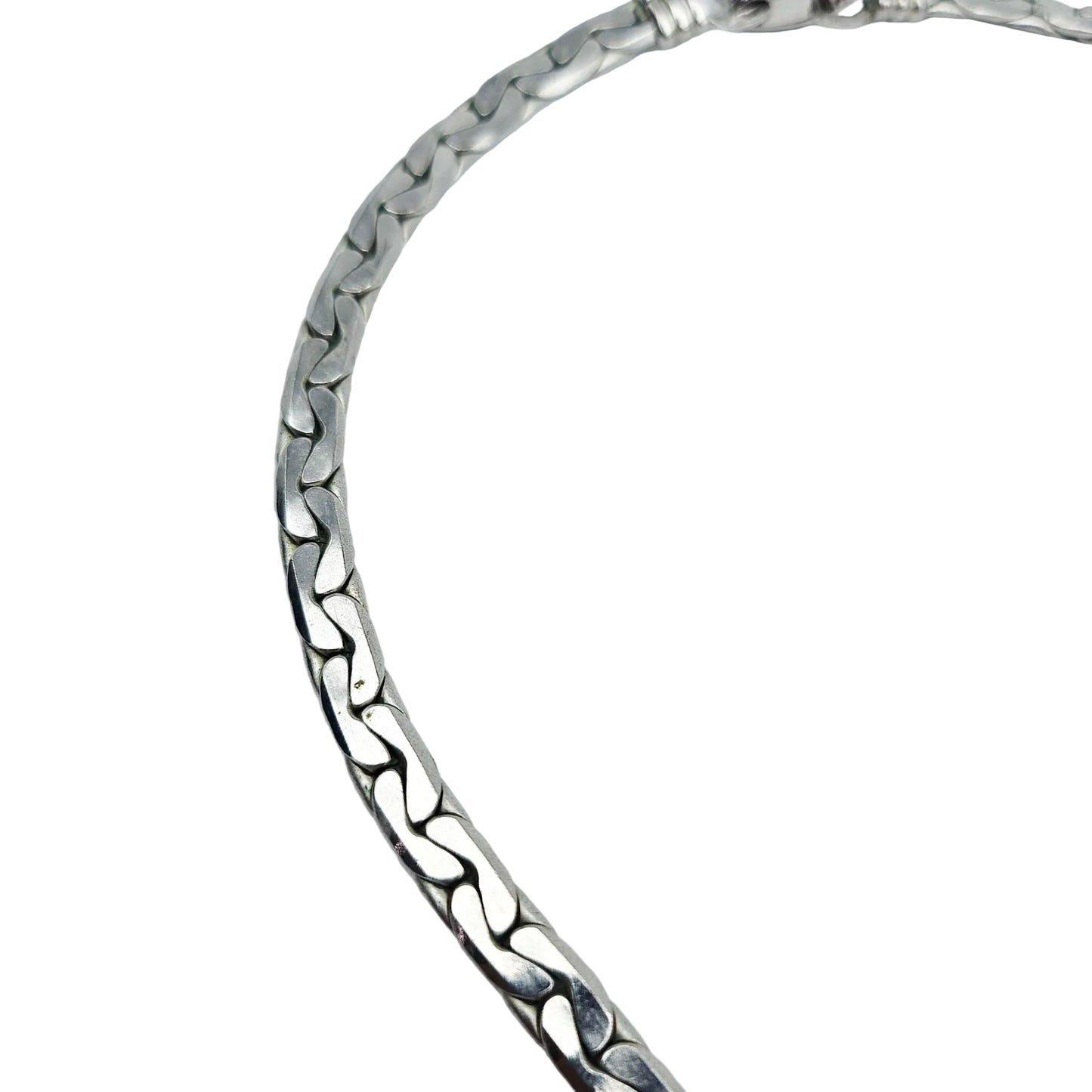 A close-up of a polished silver-toned metal chain necklace with a textured, wavy interlocking link design, shown against a plain light gray background.