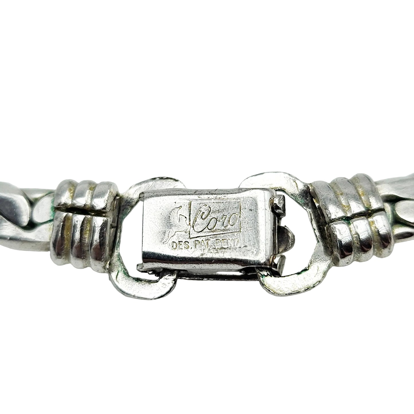 Close-up of a silver-tone metal bracelet clasp showing the engraved brand name 'Cord' and 'DES. PAT.